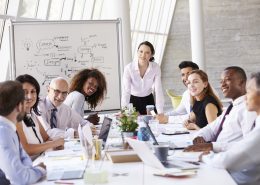 Asian Businesswoman Leading Meeting At Boardroom Table